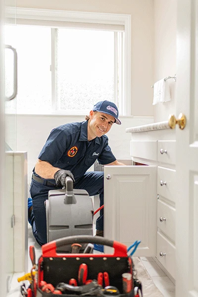 Personalized review request image ReviewWheel sends for Summit Plumbing: a smiling plumber in navy uniform finishing a job at a customer's bathroom cabinet, captioned with the customer's name, Jessica